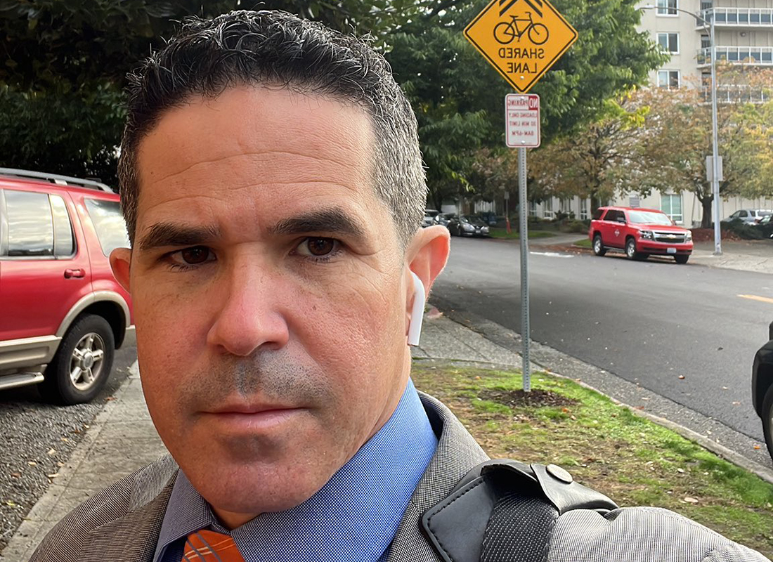 a man with a suit in front of a bike lane sign