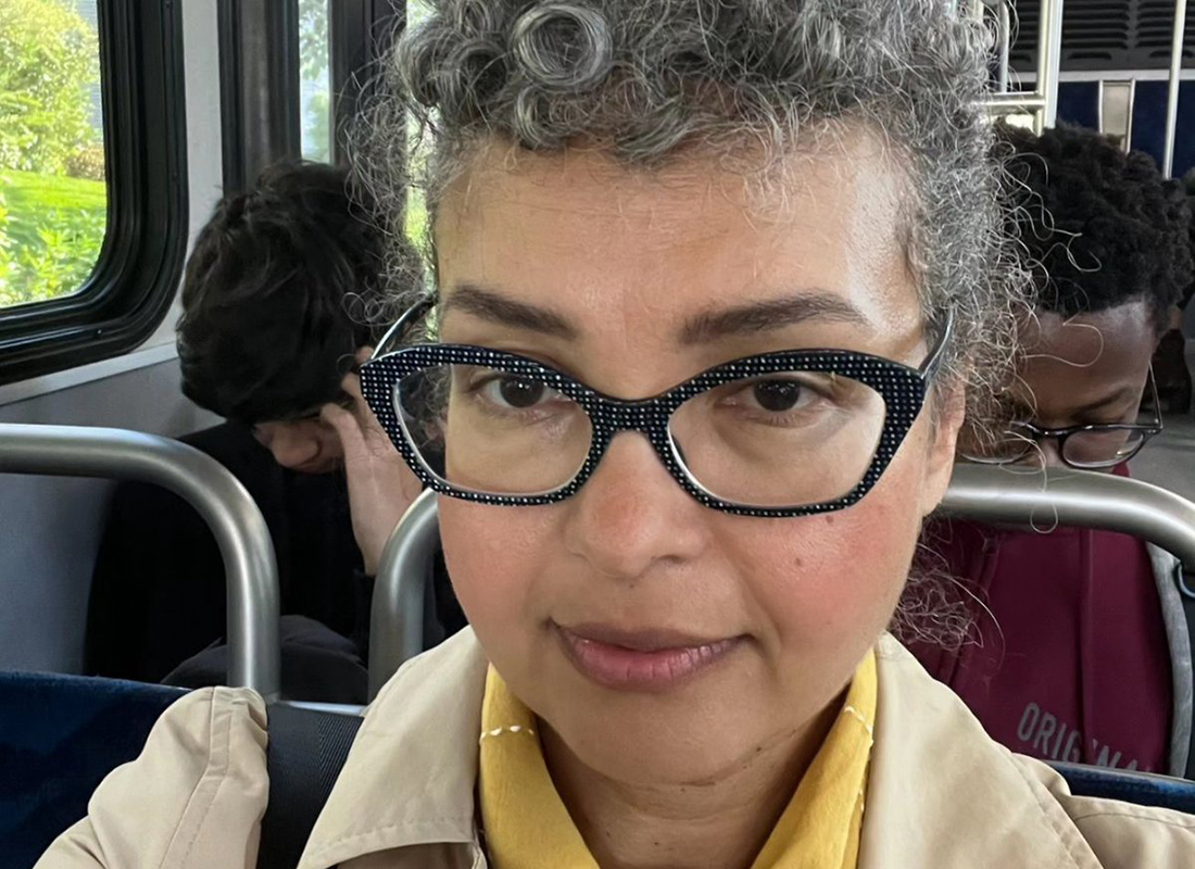 a woman with glasses and grey curly hair on the bus